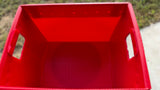 A red plastic storage crate with integrated side handles, shown from a top-down perspective.